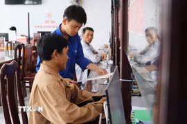 Đoàn viên xã Hỏa Lựu, Cần Thơ, hỗ trợ người dân tại Trung tâm phục vụ hành chính công. (Ảnh: Hồng Thái/TTXVN)
