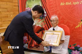 Đồng chí Nguyễn Duy Ngọc, Ủy viên Bộ Chính trị, Bí thư Trung ương Đảng, Trưởng ban Tổ chức Trung ương, trao tặng Huy hiệu 80 năm tuổi Đảng cho đồng chí Nguyễn Thanh Mậu. (Ảnh: Danh Lam/TTXVN)