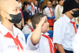 Bệnh nhi chào cờ tại Lễ khai giảng Lớp học Hoa hướng dương, Bệnh viện Ung bướu Thành phố Hồ Chí Minh. (Ảnh: Đinh Hằng/TTXVN)