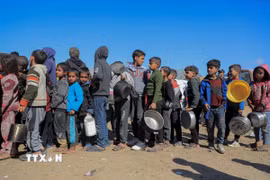 Các em nhỏ chờ được phát thực phẩm cứu trợ tại trại tị nạn ở Rafah, Dải Gaza. (Ảnh: THX/TTXVN)