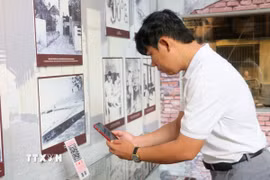 Du khách quét QR để tìm hiểu thông tin tại Nhà trưng bày thân thế, sự nghiệp Chủ tịch Tôn Đức Thắng, nằm trong Khu lưu niệm Chủ tịch Tôn Đức Thắng, thuộc xã Mỹ Hòa Hưng, tỉnh An Giang. (Ảnh: Công Mạo/TTXVN)