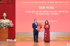 Đồng chí Bùi Thị Minh Hoài, Ủy viên Bộ Chính trị, Bí thư Trung ương Đảng, Bí thư Đảng ủy Mặt trận Tổ quốc, các đoàn thể Trung ương, Chủ tịch Ủy ban Trung ương Mặt trận Tổ quốc Việt Nam, trao quyết định cho đồng chí Nguyễn Phi Long. (Ảnh: TTXVN phát)