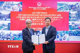 Ông Watanabe Hiroyuki - Chủ tịch Quỹ Câu lạc bộ Aeon 1% - trao khoản hỗ trợ 50.000 USD hỗ trợ người dân Việt Nam khắc phục hậu quả bão lũ. (Ảnh: Xuân Giao/TTXVN)