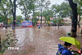 Nước ngập sân trường THPT Nguyễn Thị Minh Khai nên chiều 17/9, học sinh sẽ chuyển sang học trực tuyến. (Ảnh: TTXVN phát)