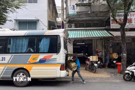 Giao nhận hàng hóa trước vị trí số 34C Nguyễn Duy Dương, nơi được liệt kê là “xe dù, bến cóc.” (Ảnh: Tiến Lực – TTXVN)