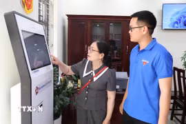 Đoàn viên thanh niên hướng dẫn người dân sử dụng dịch vụ công trực tuyến tại Trung tâm Phục vụ hành chính công xã Giao Bình, tỉnh Ninh Bình. (Ảnh: Thùy Dung/TTXVN)