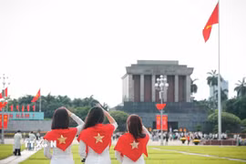 Nhiều bạn trẻ lựa chọn trang phục áo dài truyền thống khi tham quan và chụp ảnh tại khu vực Quảng trường Ba Đình, Lăng Chủ tịch Hồ Chí Minh. (Ảnh: Phạm Tuấn Anh/TTXVN)