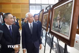 Đồng chí Khamphan Pheuiyavong, Ủy viên Bộ Chính trị, Trưởng ban Tuyên huấn Trung ương Lào và đại biểu tham quan triển lãm. (Ảnh: Xuân Tú/TTXVN)