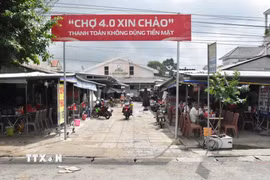 Chợ Long Hiệp triển khai mô hình “Chợ 4.0,” khuyến khích tiểu thương và người dân thanh toán không dùng tiền mặt. (Ảnh: Thanh Hòa/TTXVN)