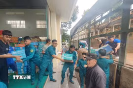 Lực lượng quân đội và nhân dân các xã phía Tây tỉnh Gia Lai sắp xếp hàng hóa gửi về cứu trợ đồng bào lũ lụt. (Ảnh: Hồng Điệp/TTXVN)