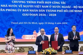Đại diện Ủy ban về người Việt Nam ở nước ngoài và Văn phòng Ủy ban Nhân dân Thành phố Hồ Chí Minh trao đổi văn kiện ký kết. (Ảnh: Liên Sơn/TTXVN)