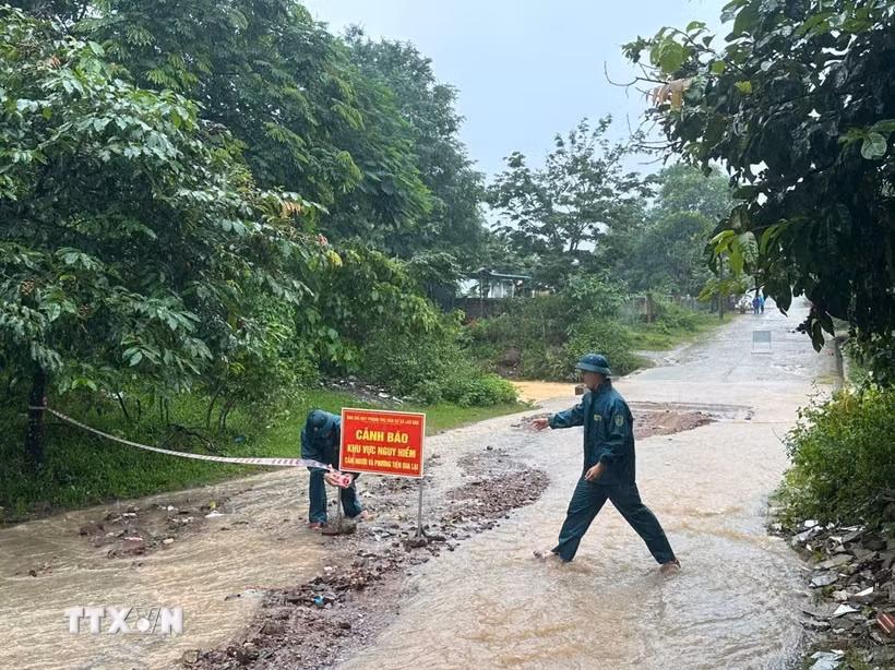 Chính quyền xã Lao Bảo (Quảng Trị) cắt cử lực lượng ứng trực, cắm biển cảnh bảo tại khu vực ngập sâu. (Ảnh: TTXVN phát)