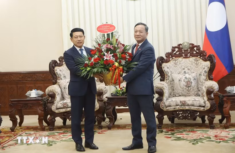 Đại sứ Việt Nam tại Lào Nguyễn Minh Tâm chuyển lẵng hoa chúc mừng của đồng chí Lê Minh Hưng, Ủy viên Bộ Chính trị, Thủ tướng Chính phủ Việt Nam chúc mừng đồng chí Saleumxay Kommasitt, Ủy viên Bộ Chính trị, Thủ tướng Chính phủ Lào. (Ảnh: Xuân Tú/TTXVN)
