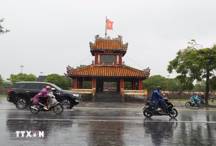 Các phương tiện di chuyển trong mưa lớn ở trước di tích Phu Văn Lâu, trung tâm thành phố Huế. (Ảnh: Nguyên Lý/TTXVN)