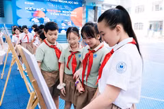 Học sinh xem tranh trưng bày về chủ đề an toàn trực tuyến tại sự kiện. (Ảnh: PV/Vietnam+)