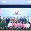 Đại sứ Việt Nam tại Lào Nguyễn Minh Tâm và Thứ trưởng Bộ Giáo dục và thể thao Lào Kingmono Phommahaxay trao giải cho đội đạt giải Nhất cuộc thi. (Ảnh: Xuân Tú/TTXVN)