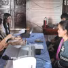 Cán bộ Trung tâm phục vụ hành chính công xã Ya Ly, tỉnh Quảng Ngãi hướng dẫn người dân nộp hồ sơ tại buổi tiếp nhận thủ tục hành chính lưu động. (Ảnh: Dư Toán/TTXVN)