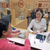 Khách hàng giao dịch tại Hội sở Agribank, Láng Hạ, Hà Nội. (Ảnh: TTXVN phát)