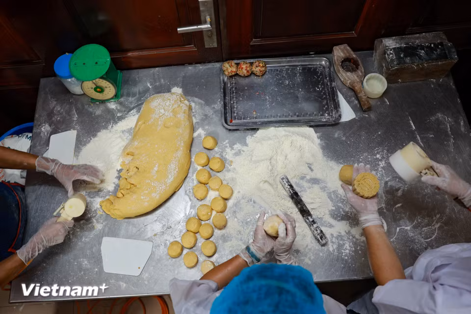 Người làm bánh cho biết, quá trình sản xuất rất công phu, với nhiều công đoạn. Mỗi chiếc bánh có trọng lượng khác nhau, đòi hỏi nguyên liệu làm nhân phải được cân tỷ mỷ. (Ảnh: Hoài Nam/Vietnam+)