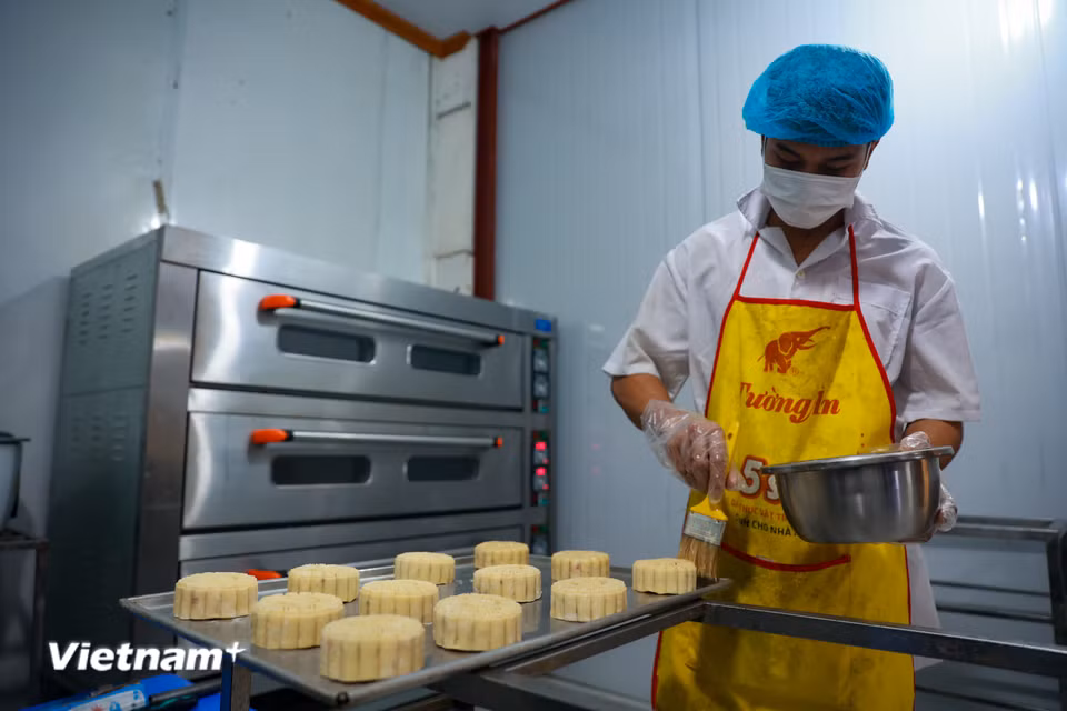 Trước khi đưa vào lò, bánh sẽ được phủ một lớp lòng đỏ trứng lên bề mặt để tạo độ thơm và màu bánh đẹp tự nhiên. (Ảnh: Hoài Nam/Vietnam+)