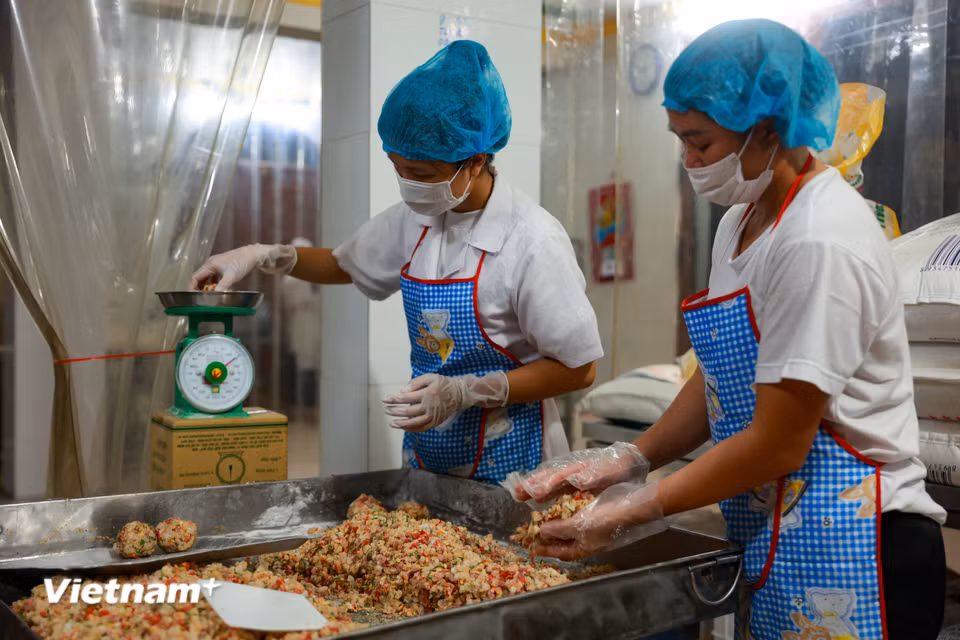 Để đảm bảo trọng lượng và tỉ lệ chính xác, nhân bánh được cân cẩn thận cho từng chiếc, dù lớn hay nhỏ. (Ảnh: Hoài Nam/Vietnam+)