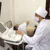 Bác sỹ khám bệnh, siêu âm cho người dân. (Ảnh: TTXVN/Vietnam+)