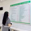 Người dân xem bảng giá các dịch vụ khám chữa bệnh. (Ảnh: T.G/Vietnam+)
