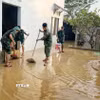 Cán bộ chiến sỹ Trung đoàn 95 giúp người dân dọn dẹp khắc phục hậu quả lũ lụt. (Ảnh: Danh Lam/TTXVN)