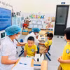 Bác sỹ theo dõi, khám sức khỏe cho trẻ em. (Ảnh: PV/Vietnam+)