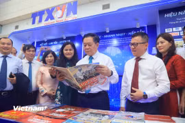 Ông Nguyễn Trọng Nghĩa, Ủy viên Bộ Chính trị, Bí thư Trung ương Đảng, Trưởng Ban Tuyên giáo và Dân vận Trung ương cùng các đại biểu tham quan gian trưng bày của Thông tấn xã Việt Nam tại Hội báo. (Ảnh: Hoài Nam/TTXVN)