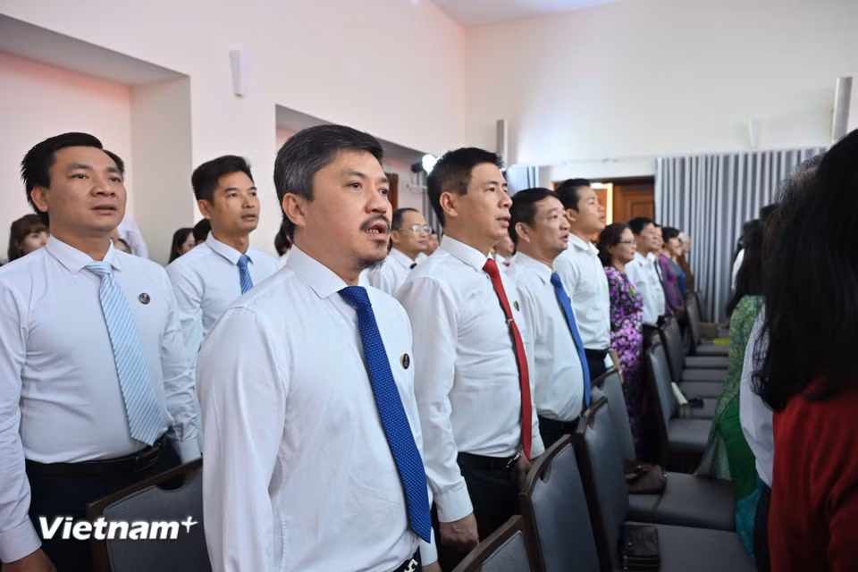 Các đại biểu đứng lên làm lễ chào cờ. (Ảnh: Minh Sơn/Vietnam+)