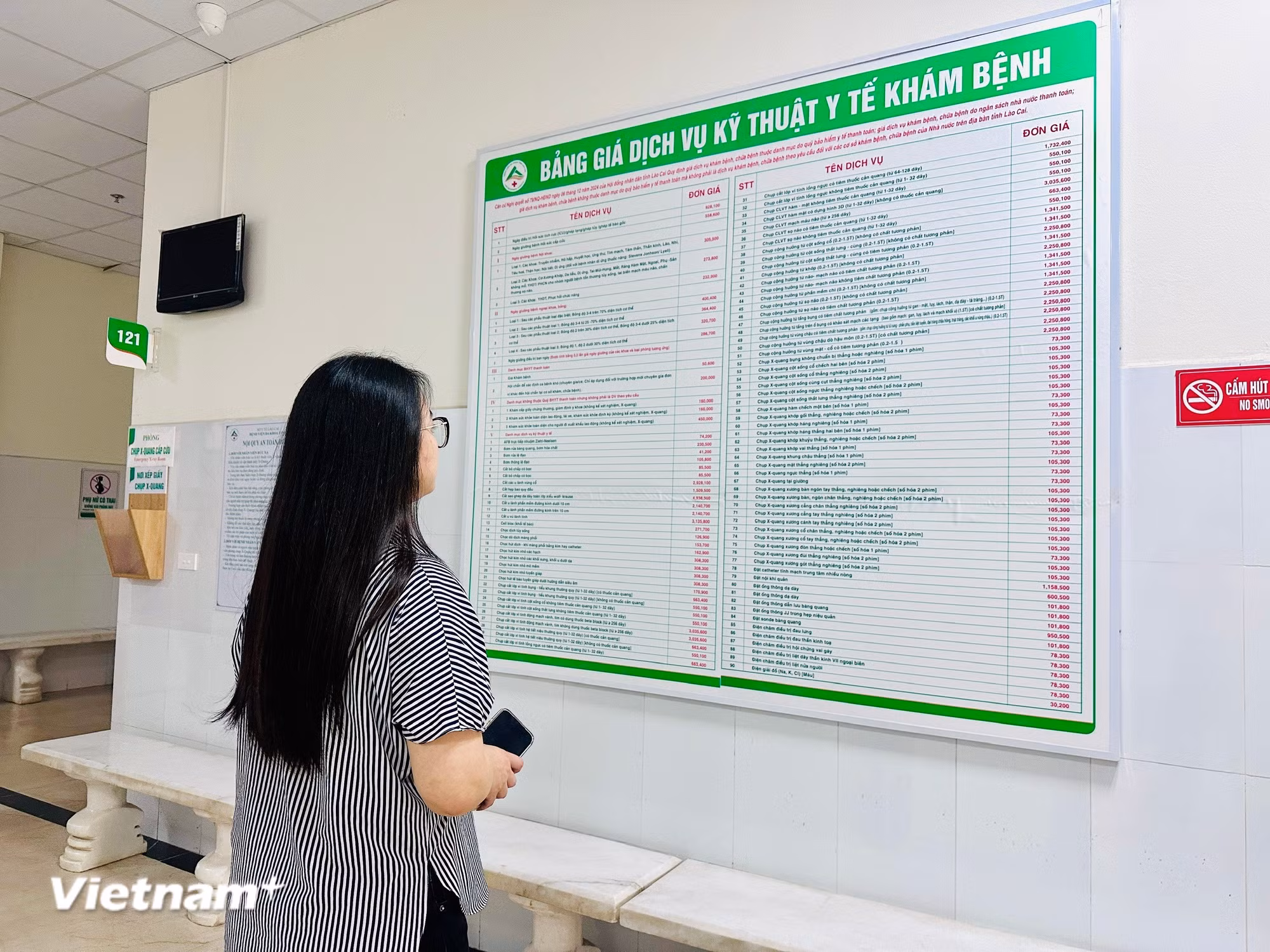 Người dân xem bảng giá các dịch vụ khám chữa bệnh. (Ảnh: T.G/Vietnam+)