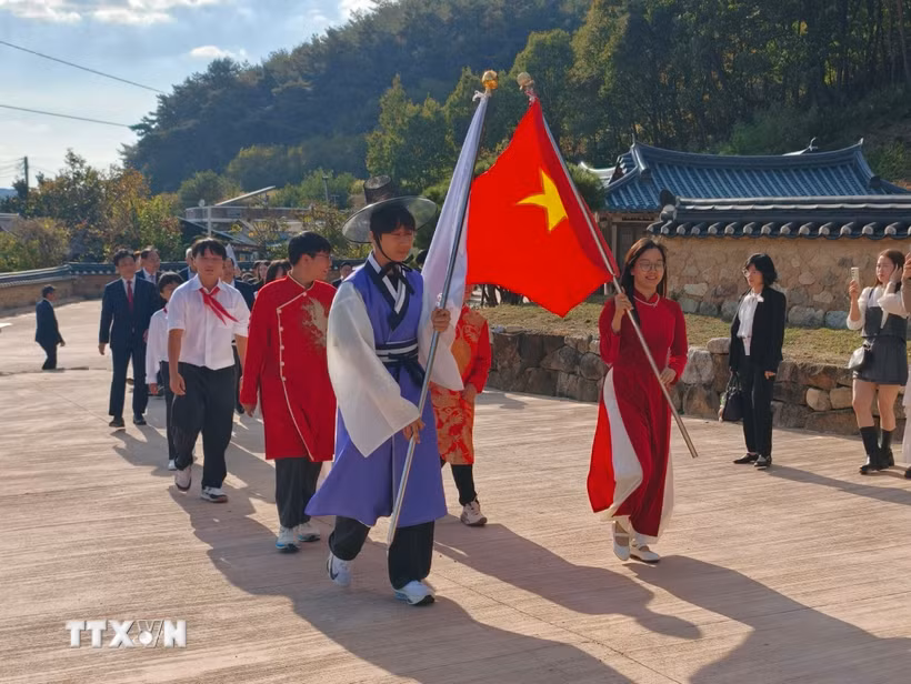 Hai lá cờ dẫn đầu đoàn diễu hành "Con đường Rồng" dài 250m tiến vào Trung Hiếu Đường. (Ảnh: Đào Lâm/TTXVN)