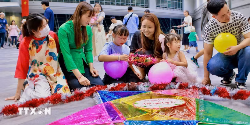 Các em nhỏ được hướng dẫn trang trí cho đèn ông sao tại chương trình vui Tết Trung thu tại Sakai, Osaka. (Ảnh: Nguyễn Tuyến/TTXVN)