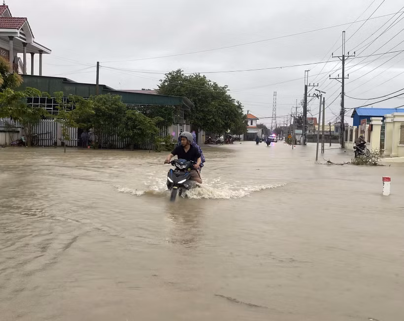 Nước lũ tràn qua đường giao thông liên xã nối Thuận Nam với Phước Dinh. (Ảnh: Công Thử/TTXVN)