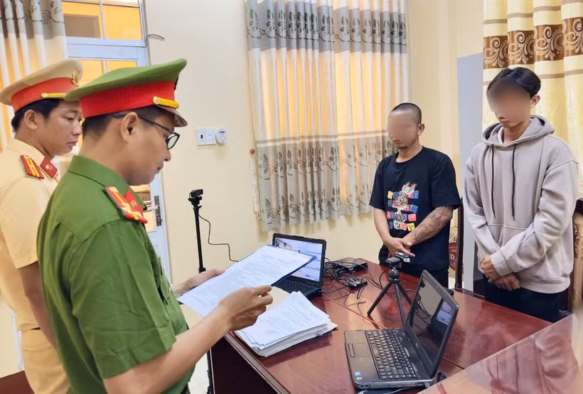 Cơ quan Cảnh sát điều tra tống đạt quyết định khởi tố bị can, lệnh cấm đi khỏi nơi cư trú đối với Võ Duy Khang (áo đen) và Phạm Văn Ý (áo xám)