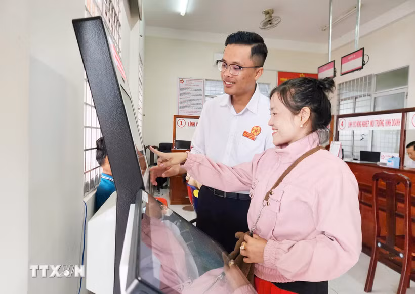 Hướng dẫn người dân thực hiện các thủ tục trên hệ thống điện tử. (Ảnh: Văn Sĩ/TTXVN)
