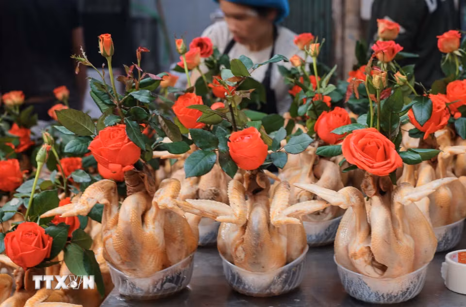 Chuẩn bị gà ngậm hoa sen, buộc cánh tiên tại chợ Hàng Bè trong phiên chợ cuối năm. (Ảnh: Hoàng Hiếu/TTXVN)