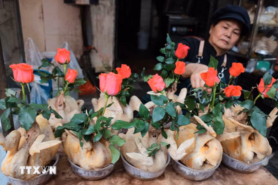 Chuẩn bị gà ngậm hoa sen, buộc cánh tiên tại chợ Hàng Bè trong phiên chợ cuối năm. (Ảnh: Hoàng Hiếu/TTXVN)
