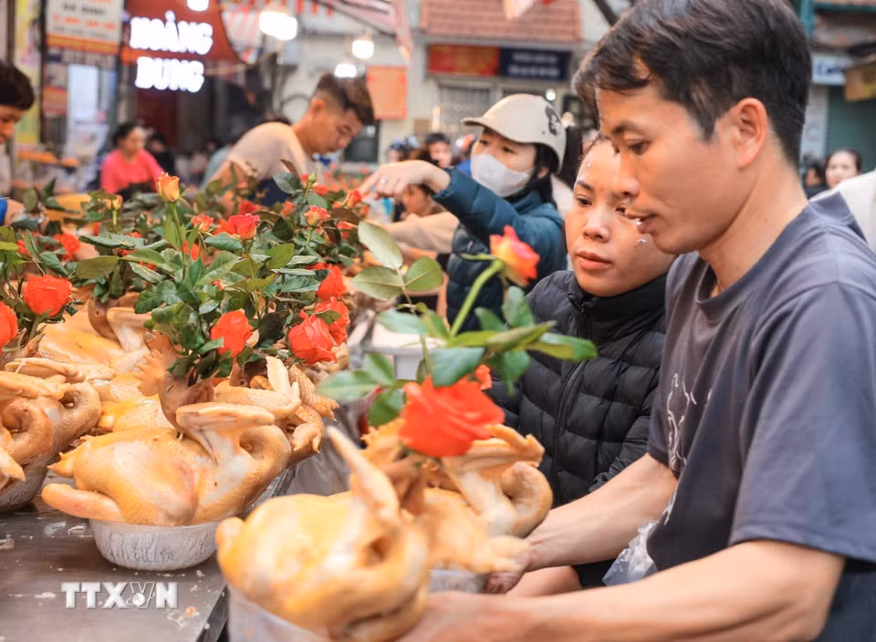 Nhiều người đến chọn mua gà - món không thể thiếu trong mâm cỗ cúng của người Việt. (Ảnh: Hoàng Hiếu/TTXVN)