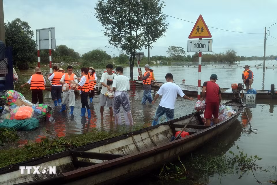 Các đoàn tình nguyện vận chuyển hàng hóa lên ghe để đưa vào những vùng ngập sâu ở thành phố Huế. (Ảnh: Đỗ Trưởng/TTXVN)