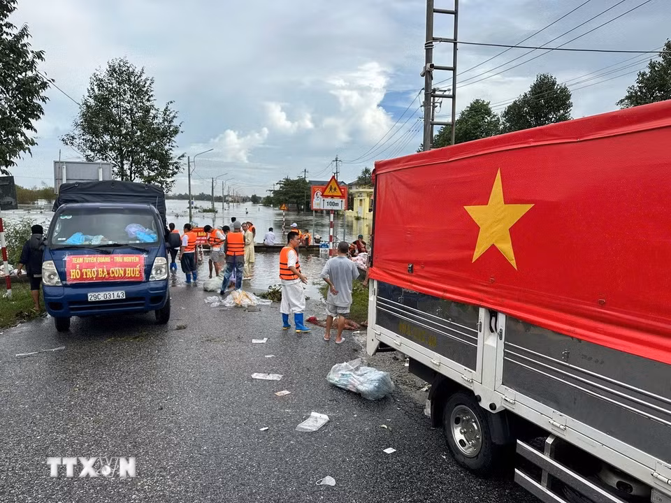 Các đoàn tình nguyện vận chuyển hàng hóa lên ghe để đưa vào những vùng ngập sâu ở thành phố Huế. (Ảnh: Đỗ Trưởng/TTXVN)