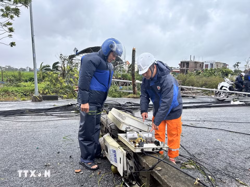 Ngành điện lực cử cán bộ xuống xã Quỹ Nhất để khắc phục thiệt hại. (Ảnh: Công Luật/TTXVN)