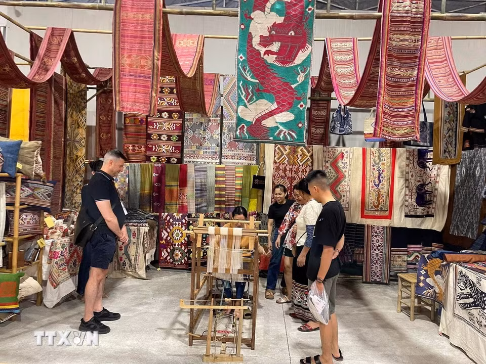 Du khách tham quan, mua sắm các sản phẩm dệt thổ cẩm Hoa Tien Brocade. (Ảnh: TTXVN phát)