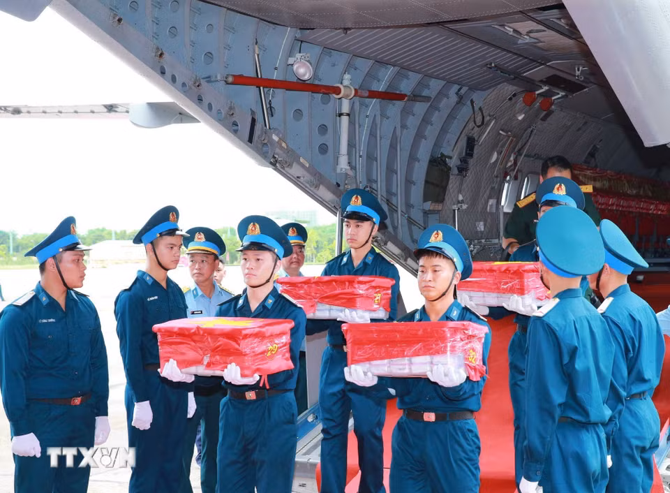 Nghi thức trang trọng chuyển mẫu hài cốt liệt sỹ từ máy bay xuống tại Sân bay Gia Lâm để làm lễ dâng hương tưởng niệm. (Ảnh: Trọng Đức/TTXVN)