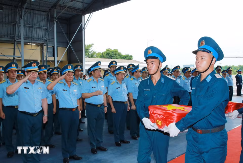 Nghi thức trang trọng chuyển mẫu hài cốt liệt sỹ từ máy bay xuống tại Sân bay Gia Lâm để làm lễ dâng hương tưởng niệm. (Ảnh: Trọng Đức/TTXVN)
