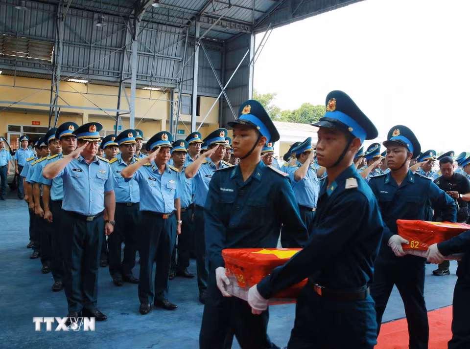 Nghi thức trang trọng chuyển mẫu hài cốt liệt sỹ từ máy bay xuống tại Sân bay Gia Lâm để làm lễ dâng hương tưởng niệm. (Ảnh: Trọng Đức/TTXVN)