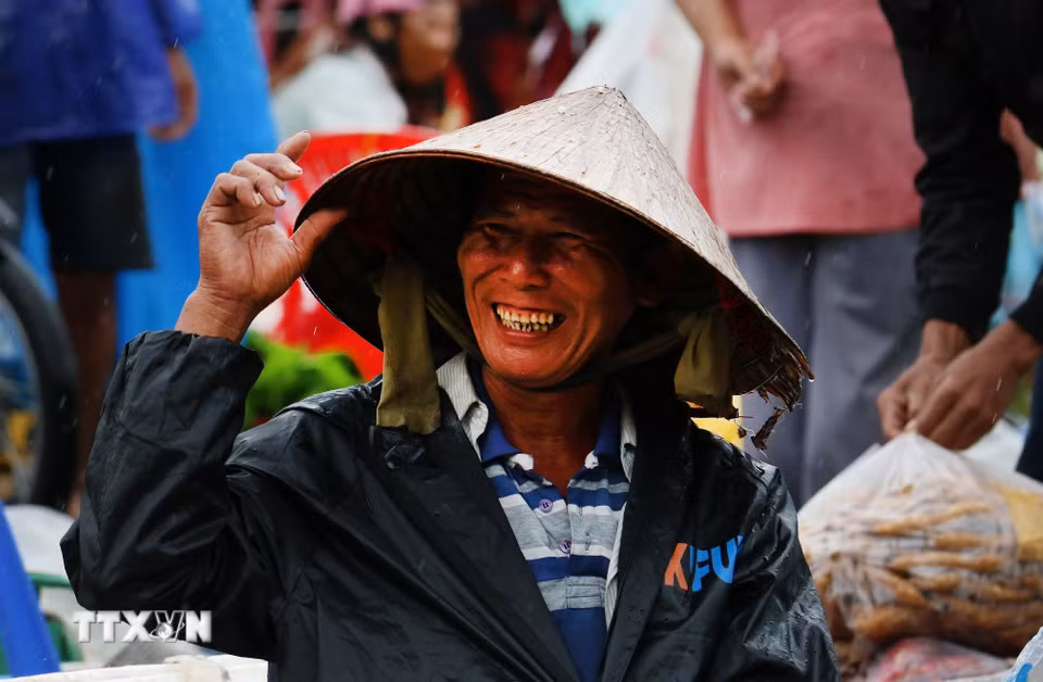 Nhiều hôm trời mưa, những người bán hàng vẫn tươi cười, kiên nhẫn ngồi bên những mẹt hàng giản dị, chờ khách ghé mua. (Ảnh: Duy Khương/TTXVN)