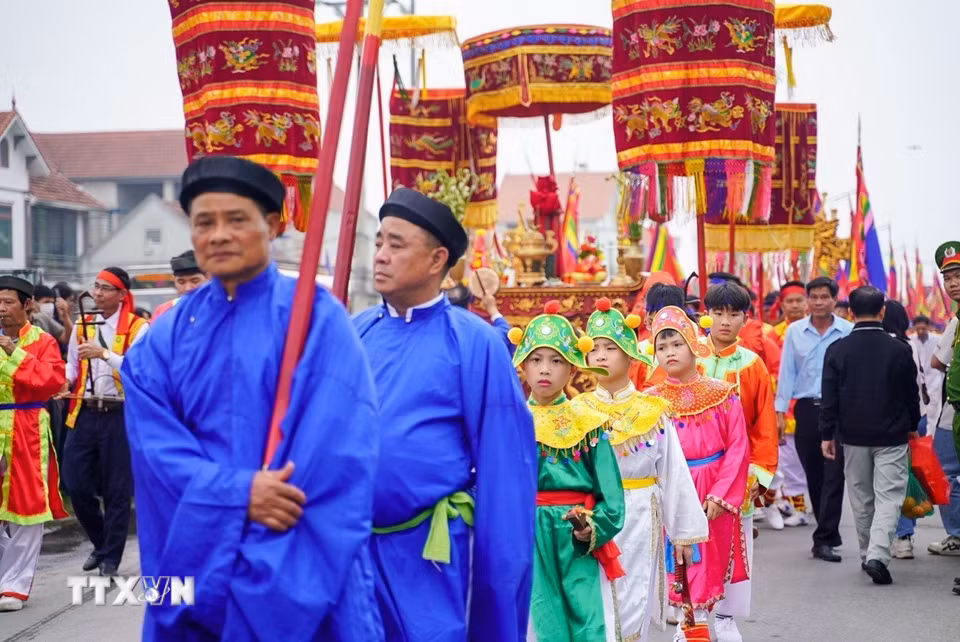 Đoàn rước gồm hơn 500 người tất cả đều là nam giới trong làng. Đi đầu là đội múa cờ, cờ thần, trống tiền, hoa roi, quân nghiềm… gần cuối là hương án, kiệu văn, chốt đoàn là cờ hậu, trống hậu, lọng tất cả có đến 22 khối người với sắc phục riêng biệt. (Ảnh: Khánh Hòa/TTXVN)