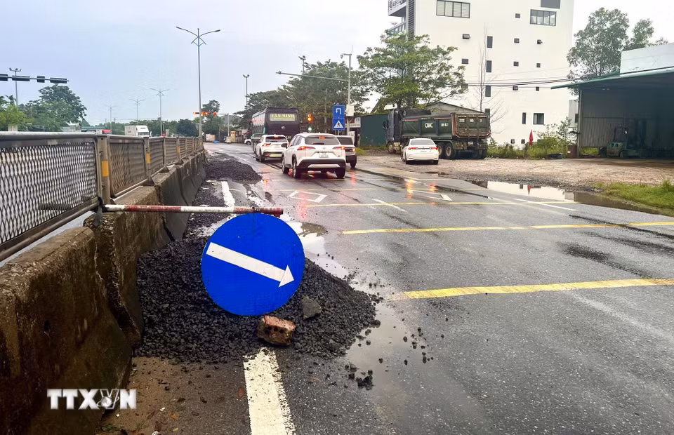Lực lượng chức năng cắm biển cảnh báo, hướng dẫn phương tiện lưu thông qua đoạn Quốc lộ 1A bị hư hỏng tại xã Hải Lăng (Quảng Trị). (Ảnh: Nguyên Linh/TTXVN)
